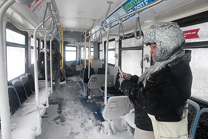Eileen Black takes pictures inside of a Chicago Transit bus that was stranded overnight on Lake Shore Drive Wednesday, Feb. 2, 2011 in Chicago. A winter blizzard of historic proportions wobbled an otherwise snow-tough Chicago, stranding hundreds of drivers for up to 12 hours overnight on the city's showcase lakeshore thoroughfare and giving many city schoolchildren their first ever snow day. (AP Photo/Kiichiro Sato)