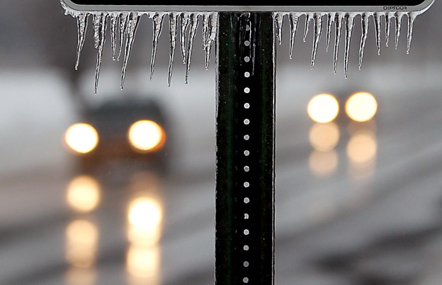 Icicles hang from a sign Wednesday, Feb. 2, 2011 in Hightstown, N.J. Freezing rain overnight left a coating of ice on New Jersey roads, encased trees and power lines, and glazed snow drifts. (AP Photo/Mel Evans)