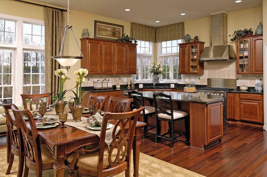 The center-island kitchen in the Bentley Place model at Holly Manor has hardwood floors, 42-inch cabinets and granite counters.