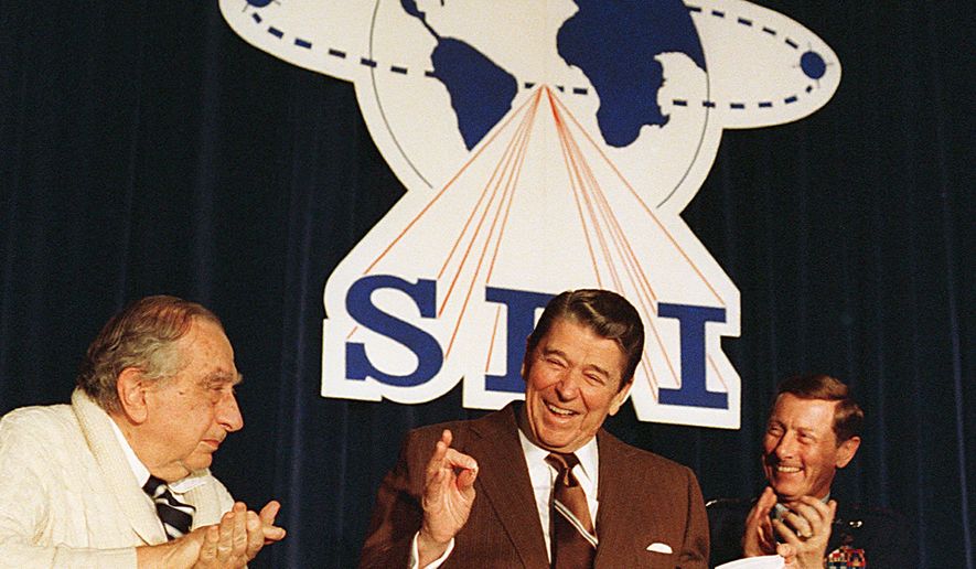 Flanked by physicist Edward Teller (left) and Lt. Gen. James A. Abrahamson, director of the Strategic Defense Initiative, President Reagan arrives to address a conference marking the first five years of the SDI program on March 14, 1988, in Washington. (Associated Press)
