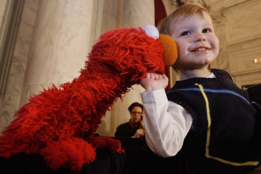 Aidan Seiden, 2, of Washington, is greeted by Sesame Street's Elmo, after a partnership announcement between the National Children's Museum and Sesame Street on Thursday, Feb. 3, 2011, in Washington. (AP Photo/Jacquelyn Martin)