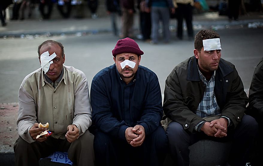 Wounded Egyptian anti-government protesters sit in Cairo's main square Thursday, Feb. 3, 2011. New clashes are heating up and shots are being fired in the air around Cairo's central Tahrir Square as anti-government protesters push back regime supporters and two sides are trading volleys of stone-throwing. (AP Photo/Emilio Morenatti)