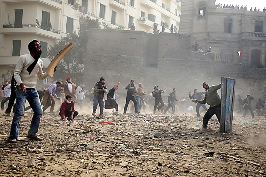 Egyptian anti-government protesters throw stones during clashes in downtown Cairo Thursday, Feb. 3, 2011. (AP Photo/Khalil Hamra)