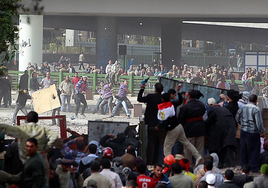 Anti-government protesters, right, clash with pro-government supporters near Cairo's main square Thursday, Feb. 3, 2011. (AP Photo/Ben Curtis)