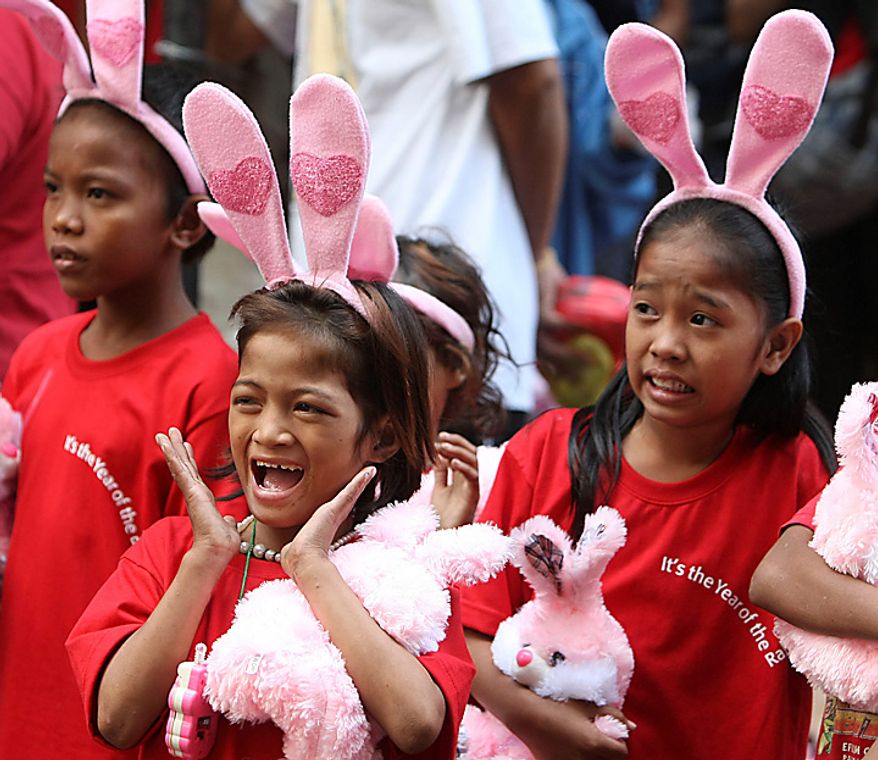 Children, wearing rabbit headbands, react to a performance during festivities at Manila's Chinatown district of Binondo to celebrate the Chinese Lunar New Year in the Philippines Thursday Feb.3, 2011, the year of the rabbit in the Chinese calendar. (AP Photo/Bullit Marquez)