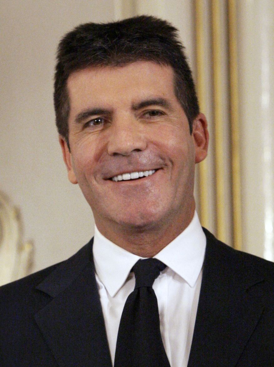 ** FILE ** In this June 6, 2010, file photo, British music mogul Simon Cowell holds his honorary Bafta Award, during the British Academy Television Awards at the London Palladium in central London. (AP Photo/Joel Ryan, file)