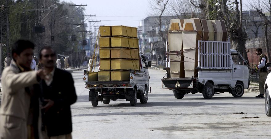 Vehicles carrying coffins head to the Pakistan army training camp in Mardan near Peshawar, Pakistan, on Thursday, Feb. 10, 2011. A suicide bomber attacked soldiers during morning exercises at a Pakistani army training camp killing 31 troops and injuring dozens others, police and the military said. (AP Photo/Mohammad Sajjad)
