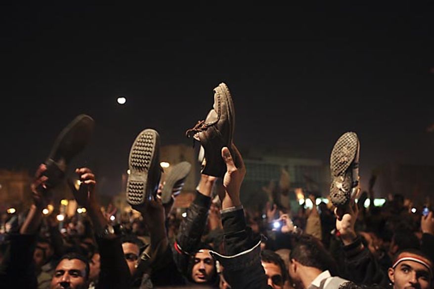 Anti-government protesters in Cairo's Tahrir Square hold their shoes up in reaction to Egyptian President Hosni Mubarak's televised statement to his nation Thursday, Feb. 10, 2011. Mr. Mubarak refused to resign in that speech, but the government announced Friday that he has stepped down. (AP Photo/Tara Todras-Whitehill)