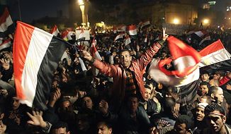 **FILE** Egyptians celebrate the news of the resignation of President Hosni Mubarak, who handed control of the country to the military, at night in Tahrir Square in downtown Cairo on Feb. 11, 2011. (Associated Press)