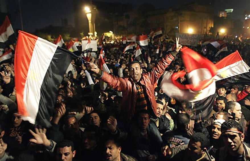 **FILE** Egyptians celebrate the news of the resignation of President Hosni Mubarak, who handed control of the country to the military, at night in Tahrir Square in downtown Cairo on Feb. 11, 2011. (Associated Press)