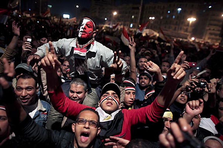 Egyptians celebrate the news of the resignation of President Hosni Mubarak, who handed control of the country to the military, at night in Tahrir Square in downtown Cairo, Egypt Friday, Feb. 11, 2011. (AP Photo/Tara Todras-Whitehill)
