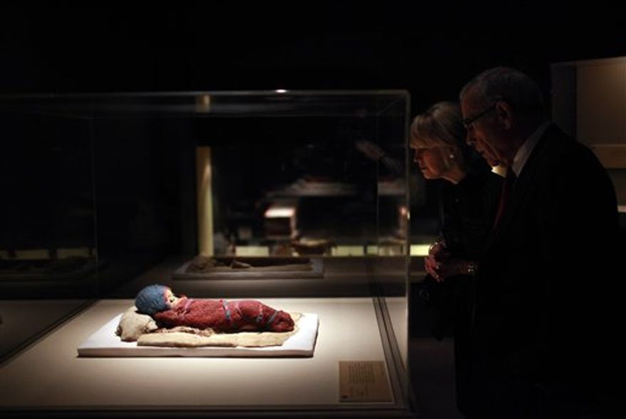 In this March 24, 2010 file photo, Edward Roski, right, a board member at the Bowers Museum, looks at a 2,800-year-old infant mummy, Baby Bluebonnet, at the "Secrets of the Silk Road: Mystery Mummies from China," exhibit at the museum in Santa Ana, Calif. A Philadelphia museum says its exhibit on the Silk Road will go on for a limited engagement after a dispute with the Chinese government. The University of Pennsylvania Museum of Archaeology and Anthropology said Friday, Feb. 11, 2011, that the exhibit will open with a full complement of mummies and more. Some of the artifacts are more than 3,800 years old. (AP Photo/Jae C. Hong, File)