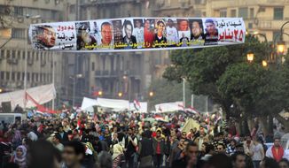 Egyptians pass under a banner honoring people who were killed during the Jan. 25 protests, at Tahrir Square, Egypt, on Saturday, Feb. 12, 2011. The Arabic sign reads &quot;who is responsible for their blood.&quot; (AP Photo/Amr Nabil)