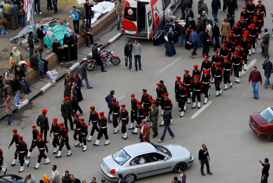 Associated Press
Egyptian army officers walk among cars and protesters Sunday in Tahrir Square in Cairo. Egypt's military is taking down the makeshift tents of protesters in an effort to allow traffic flow to return to normal for the first time in weeks.
