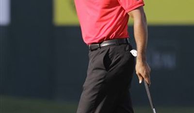 Tiger Woods from U.S. reacts after he finishes on the 18th hole during the final round of Dubai Desert Classic golf tournament at the Emirates Golf Club in Dubai, United Arab Emirates, Sunday Feb. 13, 2011. (AP Photo/Kamran Jebreili)