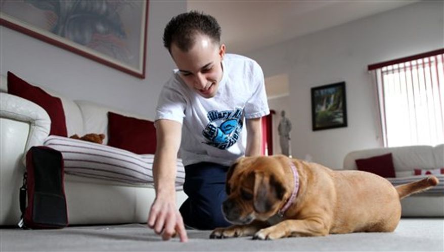 In this photo taken Feb. 12, 2011, Matthew Rosiello, 21, is aided by his mother Randy as she checks his surgically placed catheter at their home in New York. Matthew is waiting for a liver transplant and is connected to port-a cath throughout the day. Soon after telling him it was time for a liver transplant, doctors gave Matthew more tough news: he wasn't likely to get one any time soon in his home state of New York. Consider traveling to Ohio, they advised, where the wait's a lot shorter. (AP Photo/Craig Ruttle)
