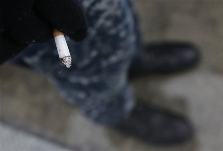 In this photo taken Friday, Feb. 11, 2011, a crew member from the USS Charlotte, a nuclear powered attack submarine, stands on a dock to smoke a cigarette at the Yokosuka Naval Base, south of Tokyo. As of January all submarines in the U.S. Navy are officially smoke free, and it's been a tense transition. (AP Photo/Greg Baker)