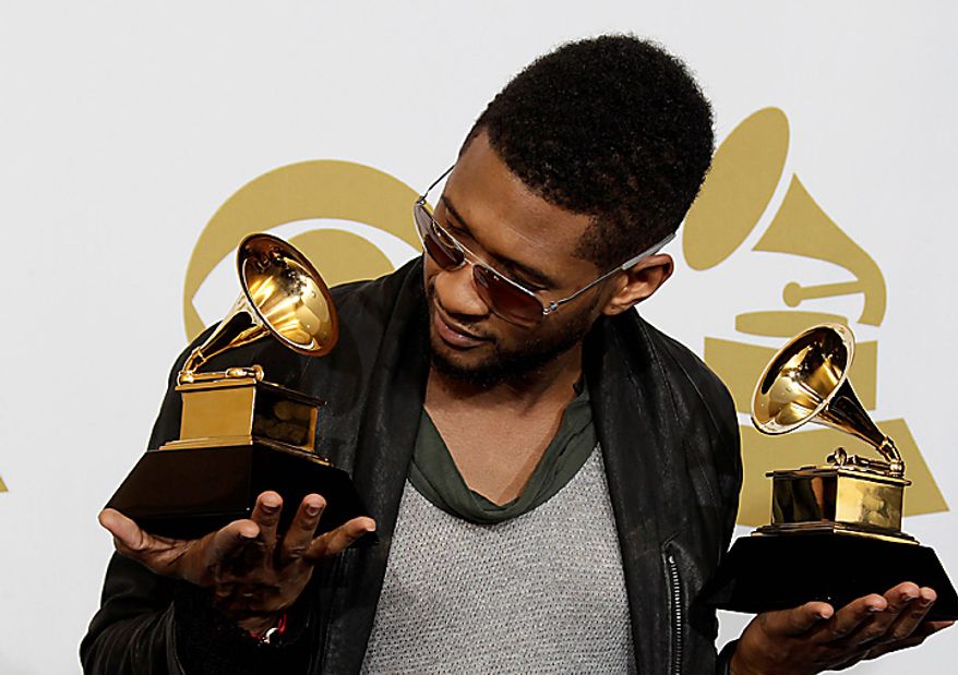 Usher poses backstage with his awards for best male R&B vocal and best contemporary R&B album at the 53rd annual Grammy Awards on Sunday, Feb. 13, 2011, in Los Angeles. (AP Photo/Jae C. Hong)