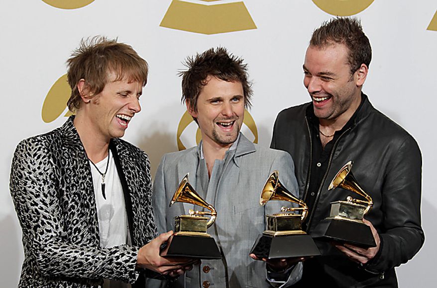 Muse, from left, Dominic Howard, Matthew Bellamy, and Christopher Wolstenholme are seen backstage with the award for best rock album at the 53rd annual Grammy Awards on Sunday, Feb. 13, 2011, in Los Angeles. (AP Photo/Jae C. Hong)