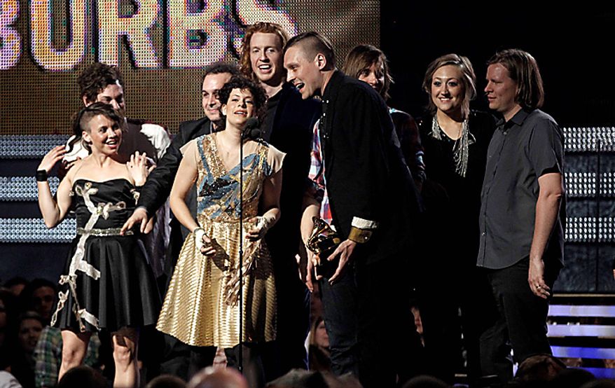 Regine Chassagne, center left, and Win Butler, center right, are joined by fellow band members of Arcade Fire to accept the award for album of the year at the 53rd annual Grammy Awards on Sunday, Feb. 13, 2011, in Los Angeles. (AP Photo/Matt Sayles)