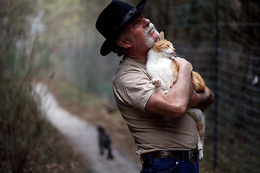 Craig Grant bought 30 acres in Lee, Fla., where he has taken in hundreds of cats at a place called Caboodle Ranch. He's created a cat village with a town hall, church, cafe and even a Wal-Mart. He's plagued by accusations of hoarding and mistreatment of the animals. "They make me love me life," he says. "I never feel alone." (AP Photo/St. Petersburg Times, Lara Cerri)
