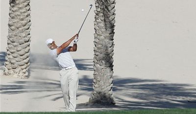 Tiger Woods of the US plays a shot from the rough on the 14th during the third round of the Dubai Desert Classic Golf Tournament at the Emirates Golf Club in Dubai, United Arab Emirates, Saturday, Feb.12, 2011.(AP Photo/Nousha Salimi)