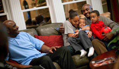 Shelton Haynes (far right) sits Tuesday with wife Tiisha, and sons Jamir, 2 (right) and Jayden, 4, while visiting with his father, Cleveland Haynes Jr. (left), at his home in Duluth, Ga. The younger Mr. Haynes moved his family to Atlanta after growing up in New York City. (Associated Press)