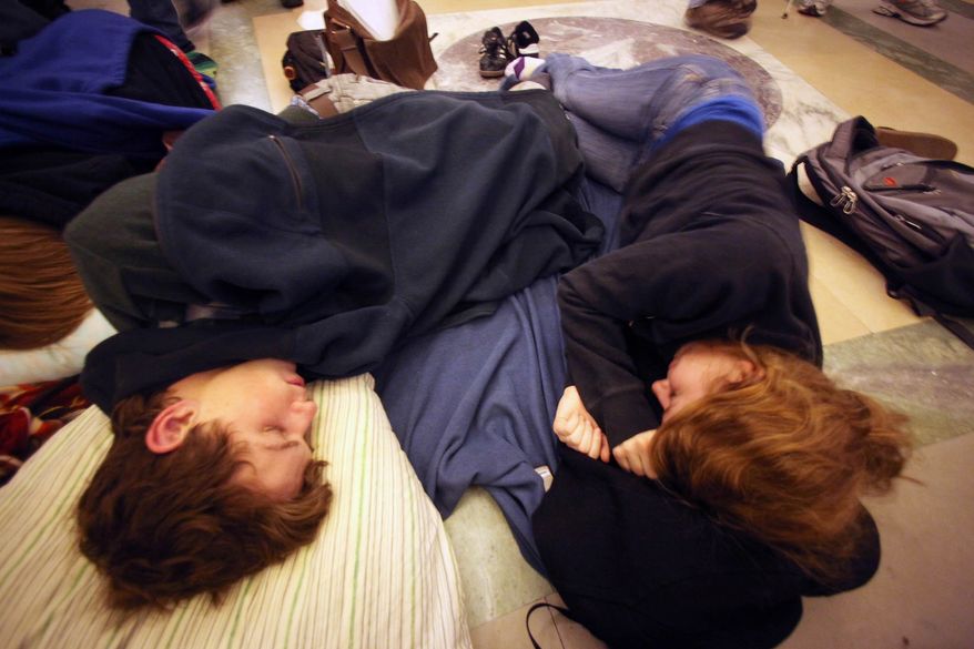 University of Wisconsin sophomores Nick Crowley (left) and Anna Wendland sleep in the Rotunda of the Capitol in Madison, Wis., as people testify into the early morning of Wednesday, Feb. 16, 2011, on the governor's proposed bill that would strip most public employees of their collective bargaining rights. (AP Photo/Wisconsin State Journal, Craig Schreiner)
