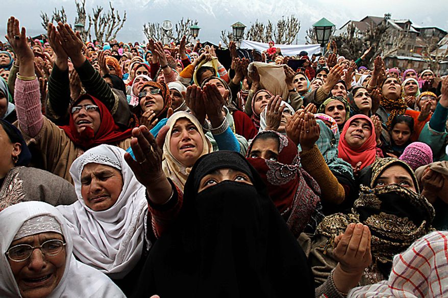 Kashmiri Muslim women raise their hands for prayers as a head priest (unseen) displays a relic of the Prophet Muhammed to mark the birth anniversary of the Prophet at the Hazratbal Shrine in Srinagar, India, on Wednesday, Feb. 16, 2011. Thousands of Kashmiri Muslims gathered at the Hazratbal shrine, which houses a relic believed to be a hair from the beard of the Prophet, to offer prayers on his birth anniversary. (AP Photo/Mukhtar Khan)