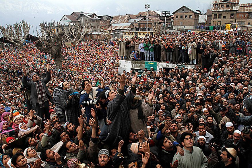 Kashmiri Muslims raise their hands for prayers as a head priest (unseen) displays a relic of the Prophet Muhammed to mark the birth anniversary of the Prophet at the Hazratbal Shrine in Srinagar, India, on Wednesday, Feb. 16, 2011. Thousands gathered at the shrine, which houses a relic believed to be a hair from the beard of the Prophet, to offer prayers on his birth anniversary. (AP Photo/Mukhtar Khan)