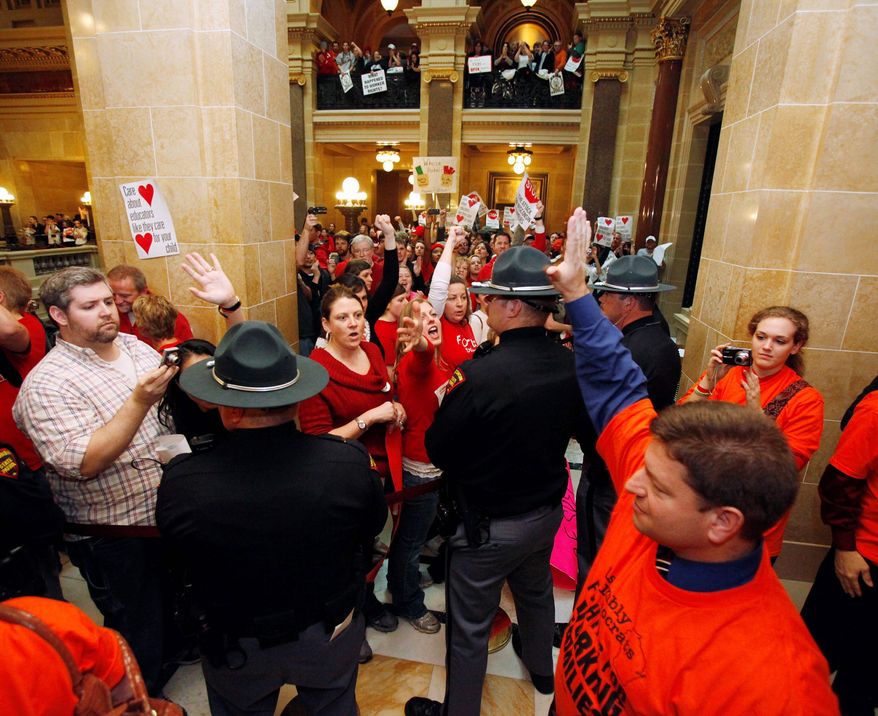 Wisconsin state Rep. Brett Hulsey, a Democrat, waves to protesters while leaving the Assembly chamber at the Wisconsin Capitol in Madison on Thursday. (Associated Press)
