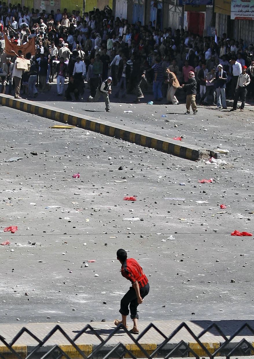 A supporter of the Yemeni government prepares to hurl a stone at anti-government demonstrators during clashes in Sanaa, Yemen, Thursday, Feb. 17, 2011. Police opened fire on protesters during clashes in a southern Yemeni port, killing two people, in the first known deaths in six days of Egypt-style demonstrations across the country's biggest cities, demanding the ouster of the president, a key U.S. ally in battling a Qaeda. (AP Photo/Hani Mohammed)