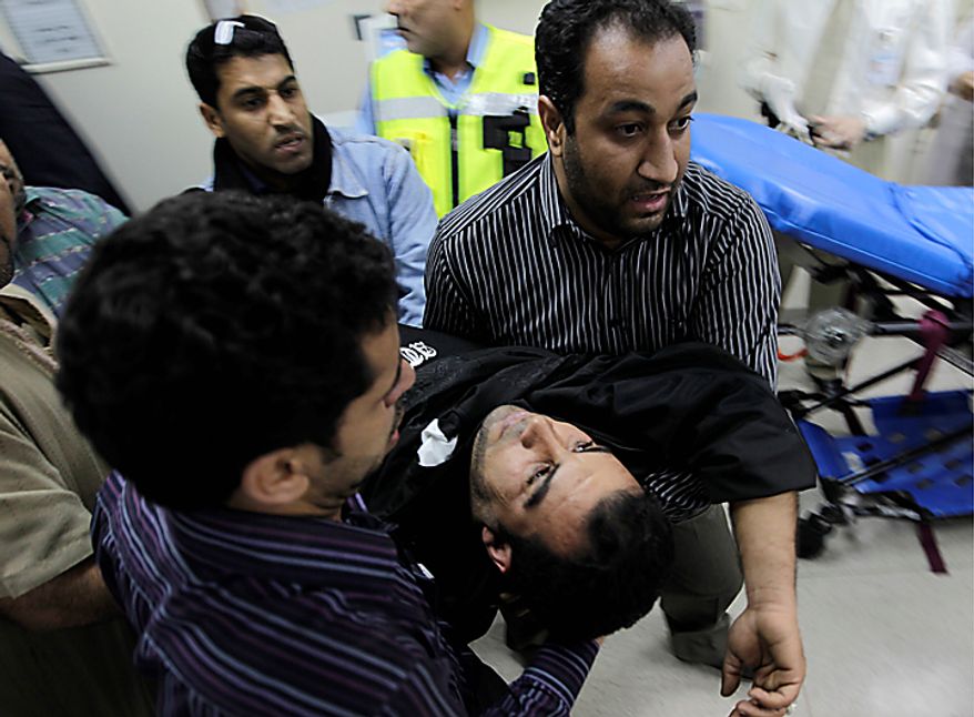 Bahraini anti-government demonstrators take an injured protester to a hospital in capital Manama early Thursday morning, Feb. 17, 2011. Armed patrols prowled neighborhoods and tanks appeared in the streets for the first time Thursday after riot police with tear gas and clubs drove protesters from a main square where they had demanded sweeping political change in this tiny kingdom. (AP Photo/Hassan Ammar)