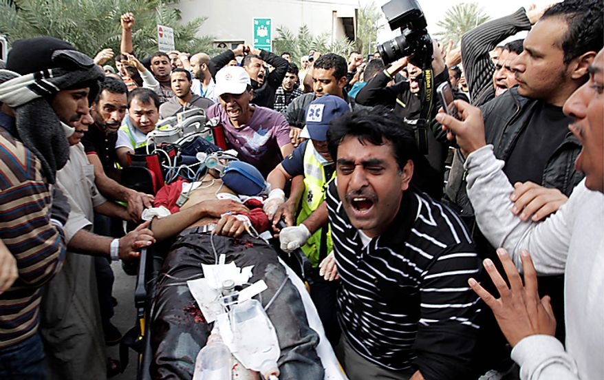 A Bahraini anti-government demonstrator lies injured on a stretcher as anti-government demonstrators take him to hospital in capital Manama early Thursday morning, Feb. 17, 2011. Armed patrols prowled neighborhoods and tanks appeared in the streets for the first time Thursday after riot police with tear gas and clubs drove protesters from a main square where they had demanded sweeping political change in this tiny kingdom. (AP Photo/Hassan Ammar)