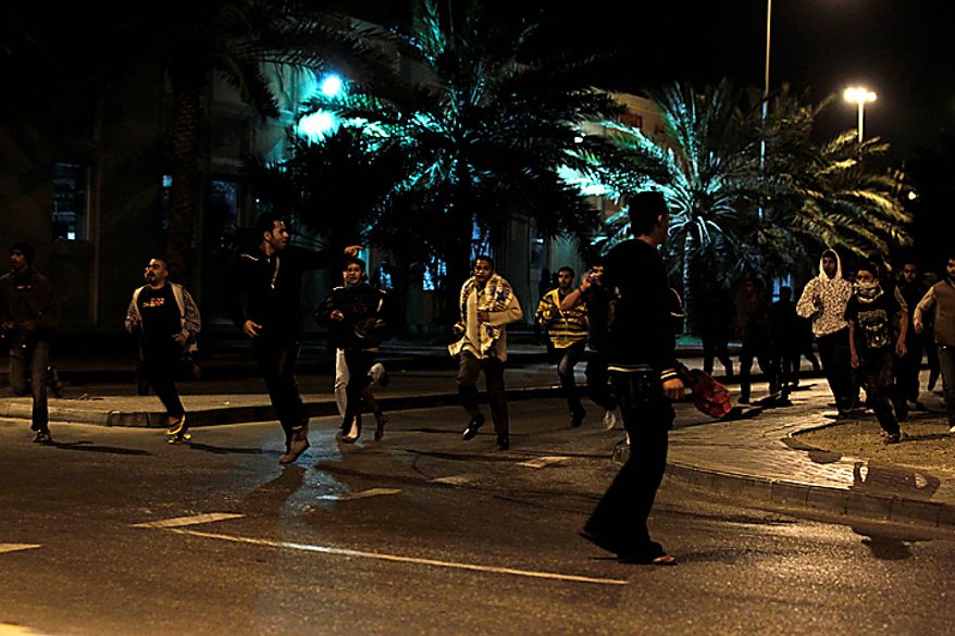 Anti-government demonstrators run away after being attacked by Bahraini riot policemen at Pearl Square, in Manama, Bahrain, early Thursday morning, Feb. 17, 2011. Riot police firing tear gas and rubber bullets stormed the landmark square occupied by anti-government protesters Thursday, driving out demonstrators and destroying a makeshift encampment that had become the hub for demands to bring sweeping political changes to the kingdom. (AP Photo/Hassan Ammar)