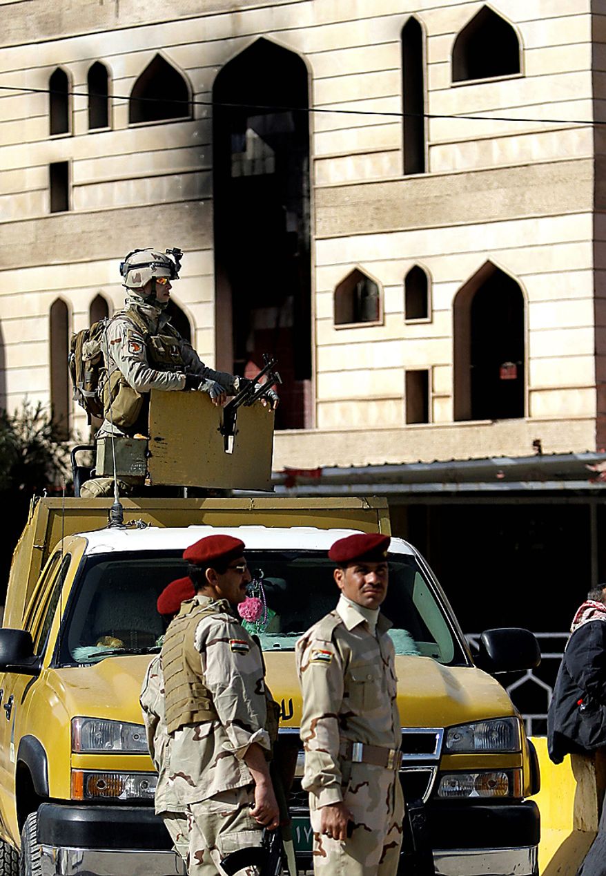 Iraqi security forces stand guard at the damaged provincial headquarters building in Kut, Iraq, Thursday, Feb. 17, 2011. About 2,000 stone-throwing demonstrators attacked local government offices on Wednesday, setting fire to a number of buildings, including the governor's house. (AP Photo/Hadi Mizban)