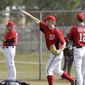 Washington Nationals right fielder Bryce Harper holds a football as part of a drill as he waits to chase a fly ball during a spring training baseball workout Tuesday, Feb. 22, 2011, in Viera, Fla. (AP Photo/David J. Phillip)