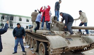 TAKING A TANK: Protesters celebrate on a tank inside a security-forces compound in Benghazi, Libya, on Monday. Demonstrators rallied in the streets of Benghazi as they claimed control of the country&#39;s second-largest city. (Associated Press)