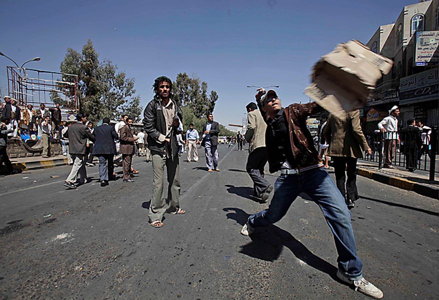 An anti-government demonstrator hurls a stone at supporters (not pictured) of the Yemeni government during clashes in Sanaa, Yemen, on Saturday, Feb. 19, 2011. Hundreds of Yemenis began demonstrating early in the day outside the university in Sanaa demanding the ouster of the country's longtime ruler as they marched toward the Justice Ministry. "The people want the ouster of the regime," they chanted. (AP Photo/Muhammed Muheisen)