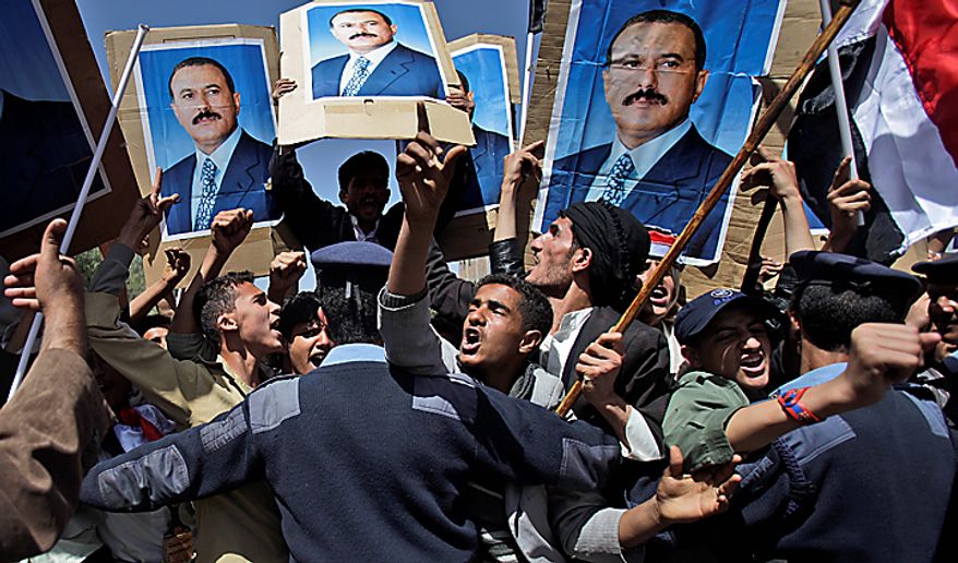 Yemeni policemen push back government supporters raising posters showing President Ali Abdullah Saleh as they shout at anti-government demonstrators (not pictured) in Sanaa, Yemen, on Sunday, Feb. 20, 2011. Some 3,000 students protesting at Sanaa University in the Yemeni capital sought to oust longtime President Ali Abdullah Saleh, a key U.S. ally in the fight against al Qaeda, and have been inspired by uprisings in Egypt and Tunisia. (AP Photo/Muhammed Muheisen)