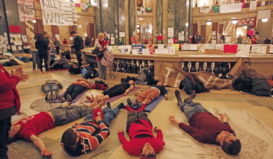 Protesters do yoga inside the state Capitol on Tuesday, Feb. 22, 2011, in Madison, Wis. Opponents to Gov. Scott Walker&#39;s bill to eliminate collective bargaining rights for many state workers are taking part in their eighth day of demonstrations. (AP Photo/Jeffrey Phelps)
