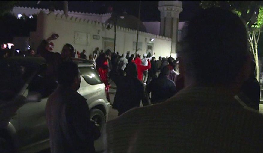 Anti-government protesters demonstrate in the street in the Libyan capital Tripoli in the early hours Tuesday Feb. 22, 2011, in this image taken from TV. The bodies of protesters shot to death by forces loyal to Moammar Gadhafi were left on the streets of a restive district in the Libyan capital Tuesday, an opposition activist and a resident said, while the longtime leader defiantly went on state TV to show he was still in charge. (AP Photo/APTN)