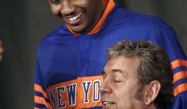 New York Knicks owner James Dolan (bottom) bounces a basketball as he poses for photographs with Carmelo Anthony, the Knicks&#x27; newest player, during a Feb. 23 introductory news conference in New York. (Associated Press)
