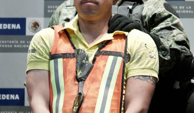 'TWEETY BIRD' DETAINED: A soldier escorts Julian Zapata Espinoza in Mexico City on Wednesday. (Associated Press)