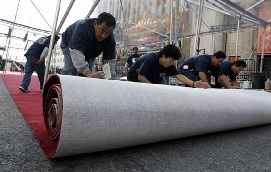 Workers roll out the red carpet for the 83rd Academy Awards outside the Kodak Theatre in Los Angeles, Wednesday, Feb. 23, 2011. The Academy Awards will be held Sunday. (AP Photo/Matt Sayles)