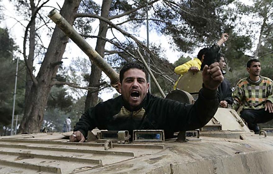 In this photo released by China's Xinhua News Agency, an anti-government protester celebrates on an army tank in the east Libyan city of Albayda Thursday, Feb. 24, 2011. (AP Photo/Xinhua, Nasser Nouri)