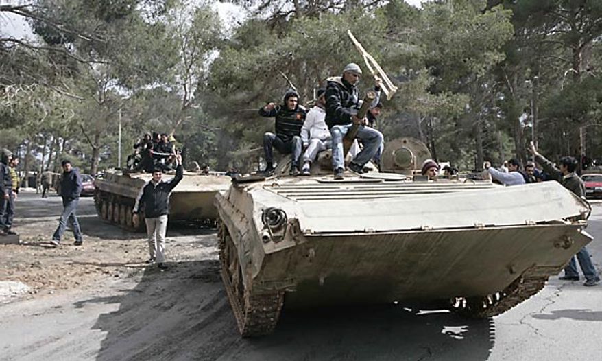 In this photo released by China's Xinhua News Agency, anti-government protesters celebrate on army tanks in the east Libyan city of Albayda Thursday, Feb. 24, 2011. (AP Photo/Xinhua, Nasser Nouri)