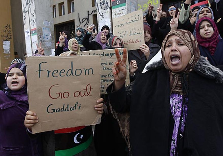 Protesters shout slogans against Libyan leader Moammar Ghadafi during the demonstration before the Friday prayer in Benghazi, Libya, on Friday Feb. 25, 2011. Militias loyal to Col. Gadhafi opened fire on protesters streaming out of mosques in the Libyan capital on Friday, demanding the regime's ouster, witnesses said, reporting at least four killed. Across rebellious cities in the east, tens of thousands held rallies in support of the first Tripoli protests in days. (AP Photo/Hussein Malla)