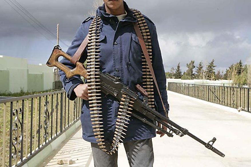 In this photo released by China's Xinhua News Agency, a man holding an automatic machine gun poses in the east Libyan city of Albayda Thursday, Feb. 24, 2011. (AP Photo/Xinhua, Nasser Nouri)