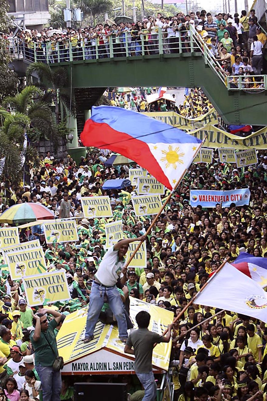 A man on top of a truck waves the Philippine flag, re-enacting "People Power" revolution during the celebration of its 25th anniversary Friday, Feb. 25, 2011, in suburban Pasig City east of Manila, Philippines. The nearly bloodless four-day people power revolution 25 years ago saw the ouster of the late strongman Ferdinand Marcos from 20-year rule and helped install now President Benigno Aquino III's mother Corazon "Cory" Aquino to the presidency. (AP Photo/Pat Roque)